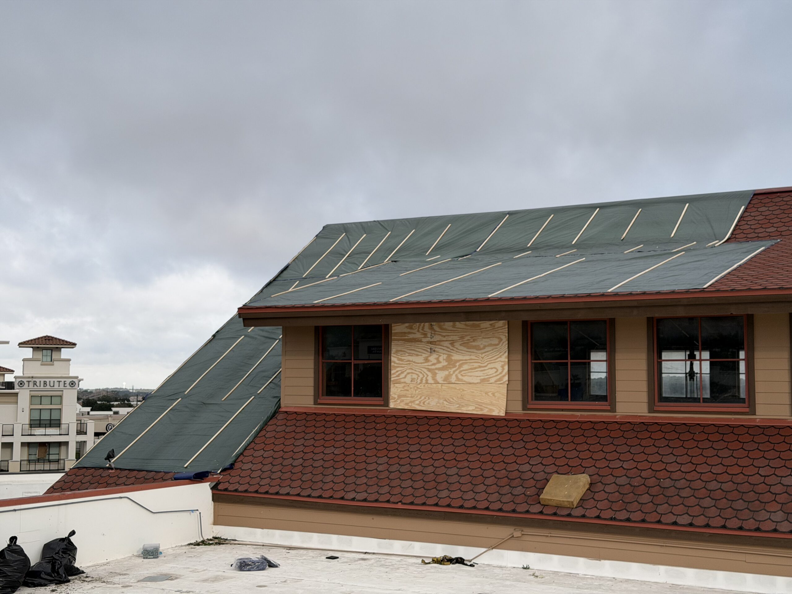Commercial roof temporary dry-in secured over storm-damaged roofing in San Antonio, TX