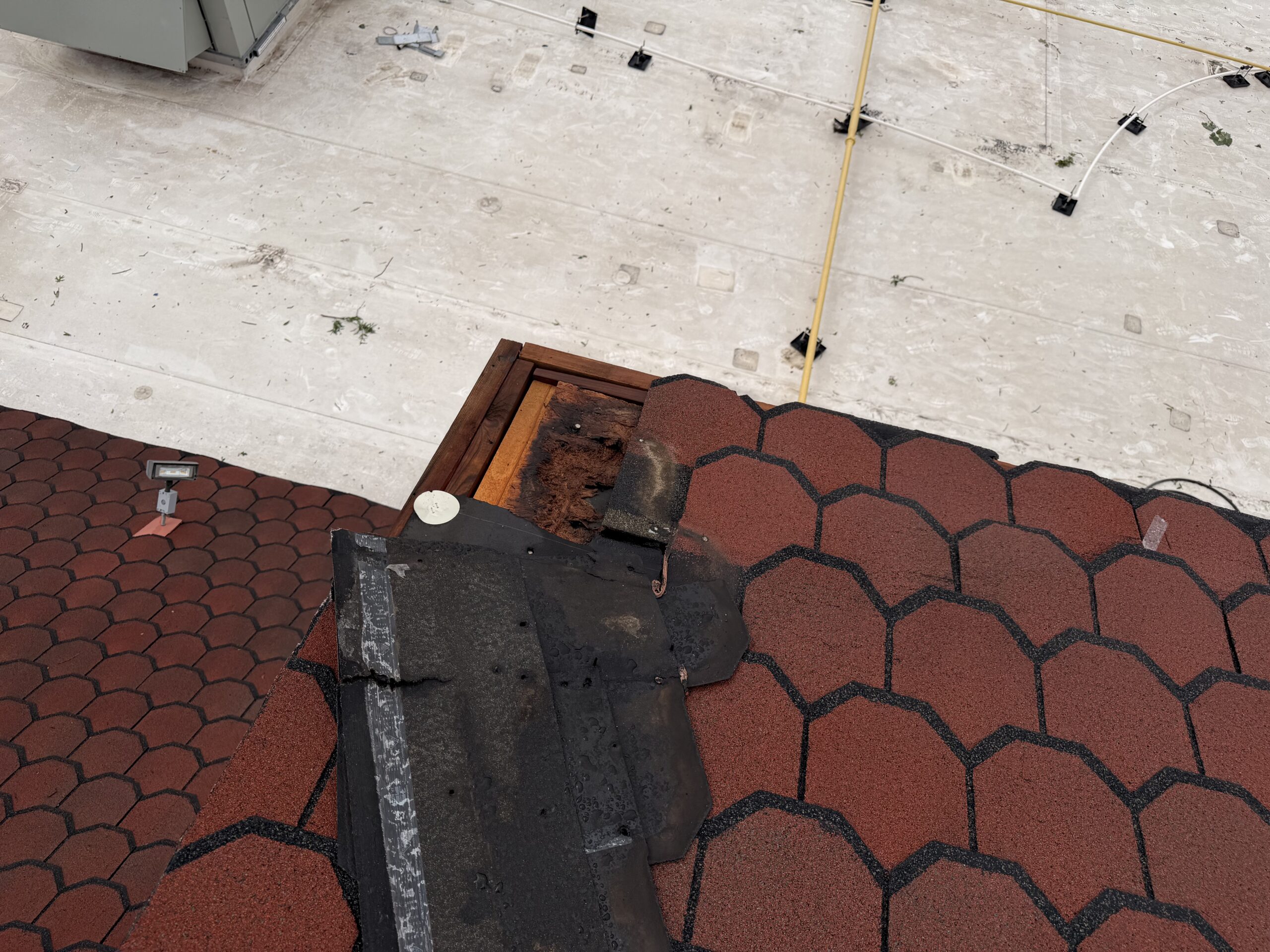 Damaged and missing roofing materials on a commercial roof following a storm in San Antonio, TX